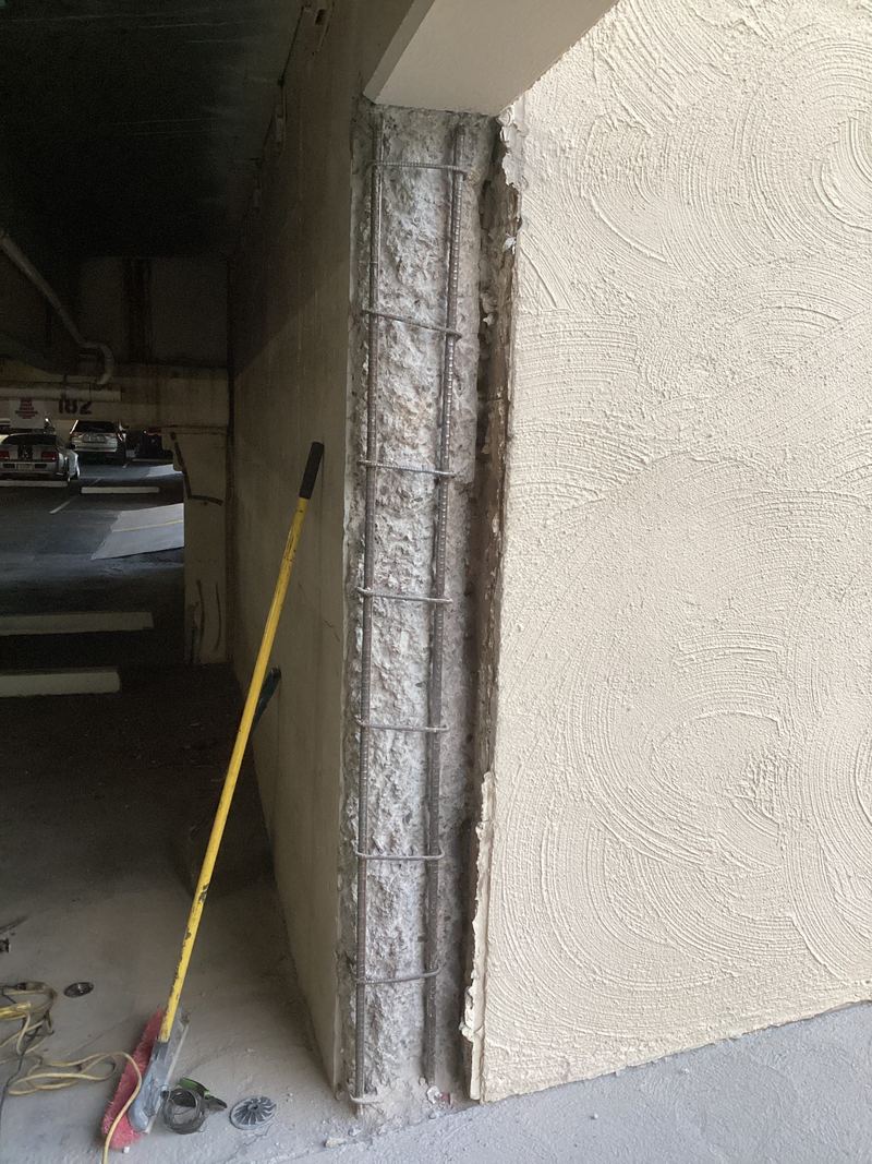 Concrete column with damaged concrete along its face, before repair