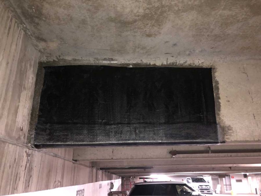 Carbon fiber wrap on a parking garage beam, cars parked below