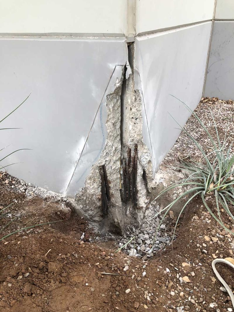 Tilt panel corner with broken concrete and exposed rusted rebar, before repair